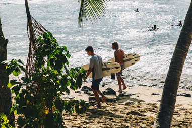 two surfers walking along the beach