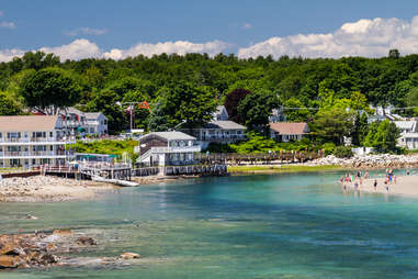 people playing on a beach in front of a Maine beach house