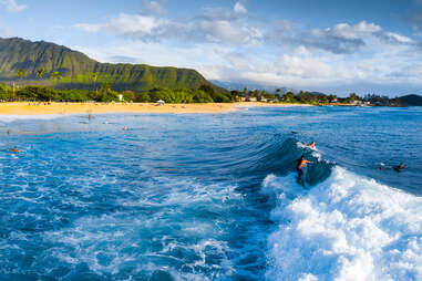 Panorama of the surf spot Makaha with the surfer riding the wave. Oahu, Hawaii