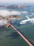 Alaska Airlines plane flies over the Golden Gate bridge in San Francisco